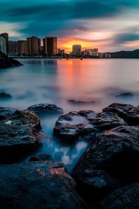 Scenic view of river against sky at sunset