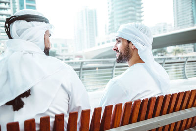 Smiling man having discussion with coworker against building