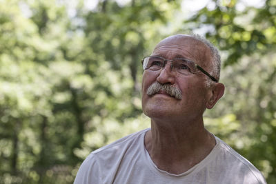 Portrait of man wearing hat against trees