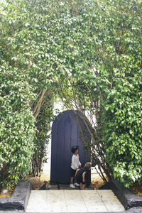 Women sitting on plant against trees