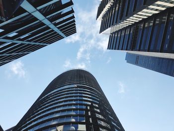Low angle view of skyscrapers against blue sky