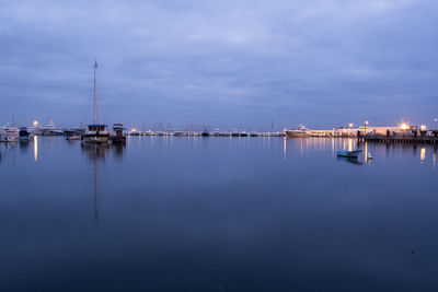 Sailboats in marina at harbor against sky