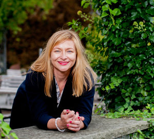 Portrait of smiling woman leaning on retaining wall