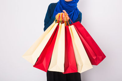 Close-up of red shopping bags against white background