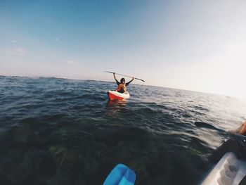 Rear view of man in sea against sky