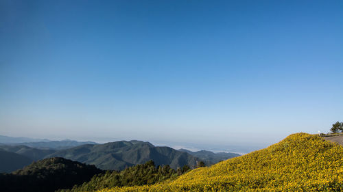 Scenic view of mountains against clear blue sky