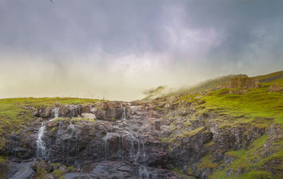 Scenic view of waterfall against sky