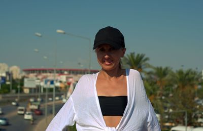 Portrait of smiling woman standing against sky