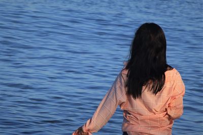 Rear view of woman standing in sea