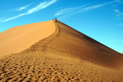 Low angle view of sand dunes against sky