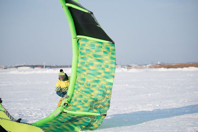 Person standing on snow covered field against sky