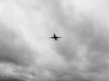 Low angle view of airplane flying against sky