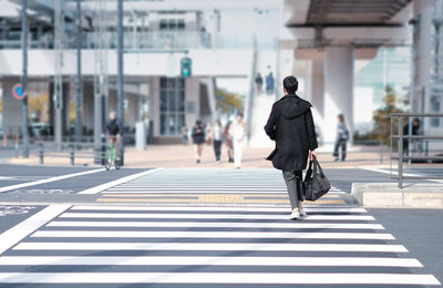 Rear view of man walking on road