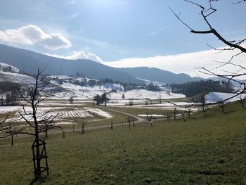 Scenic view of field and mountains against sky