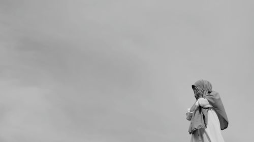 Woman photographing against sky