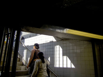 Rear view of man and woman standing by window