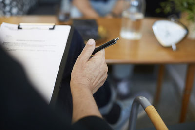 Cropped image of male therapist with reports on clipboard at community center