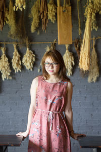 Portrait of woman standing against wall