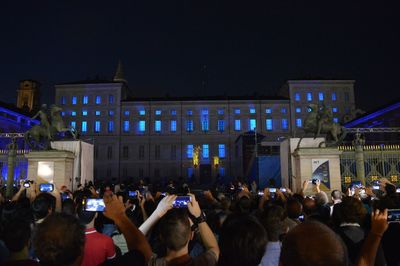 Group of people in front of buildings at night