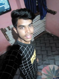 Portrait of young man standing at home