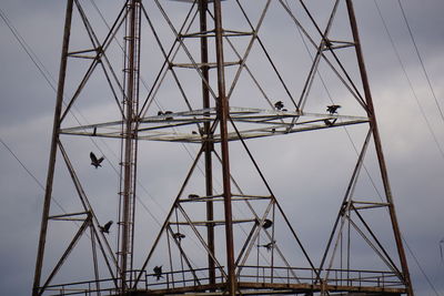 Low angle view of electricity pylon against sky