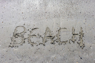 High angle view of text on sand