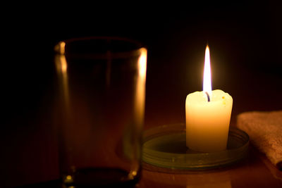 Close-up of illuminated candles in darkroom