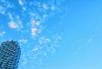 Low angle view of modern building against blue sky