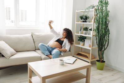 Young woman sitting on sofa at home