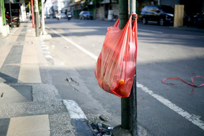 Red plastic bag on footpath in city