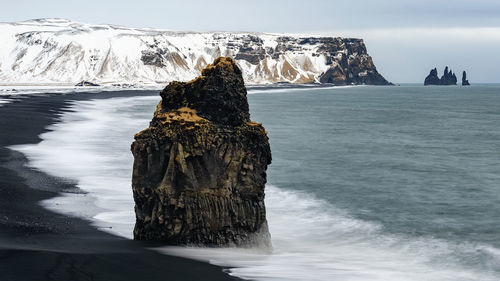 Close-up of rock in sea against sky