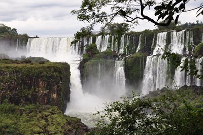 Scenic view of waterfall against sky