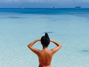 Rear view of shirtless man in sea