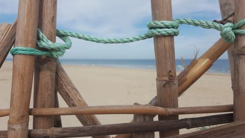 Close-up of rope on beach against sky