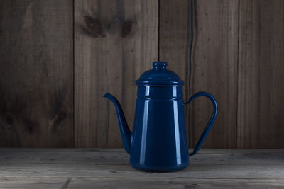 Close-up of blue teapot on wooden table