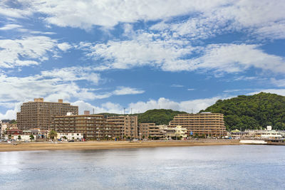 Buildings by sea against sky in city