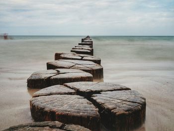 Stack of stones on beach against sky