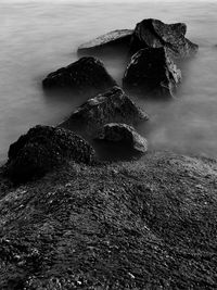 Close-up of rocks on sea shore against sky