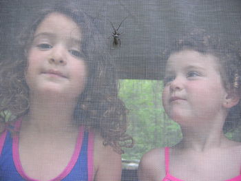 Close-up portrait of a girl looking through window