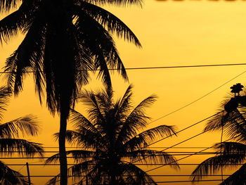 Silhouette palm trees against sky during sunset