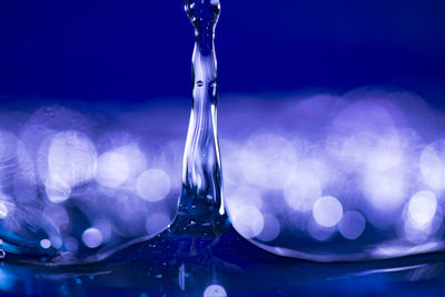 Close-up of water drop against blue sky
