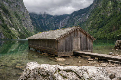 Scenic view of house in lake and mountains against sky