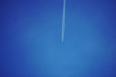 Low angle view of vapor trail against blue sky