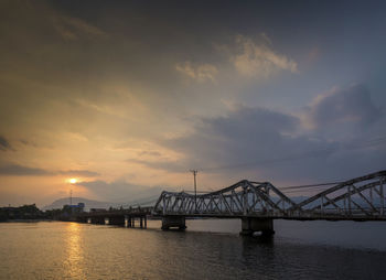 Bridge over river at sunset