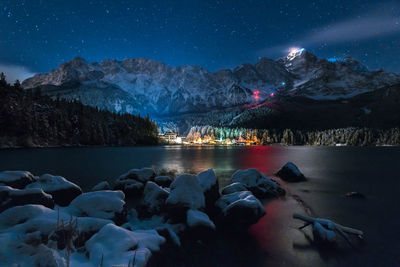 Scenic view of lake against mountain range at night