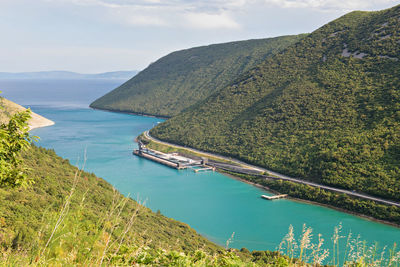 High angle view of sea and mountains against sky