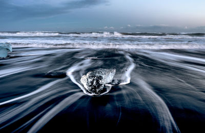 Long exposure of waves in sea against sky