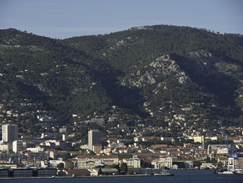 High angle view of townscape by sea against sky