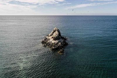 View of rock in sea against sky