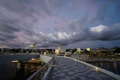 City at waterfront against cloudy sky